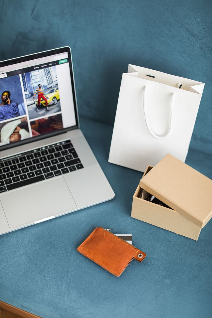 Crafting Captivating Headlines: Your awesome post title goes here A high-angle view of online shopping items including a laptop, gift bags, and wallet on a blue surface.